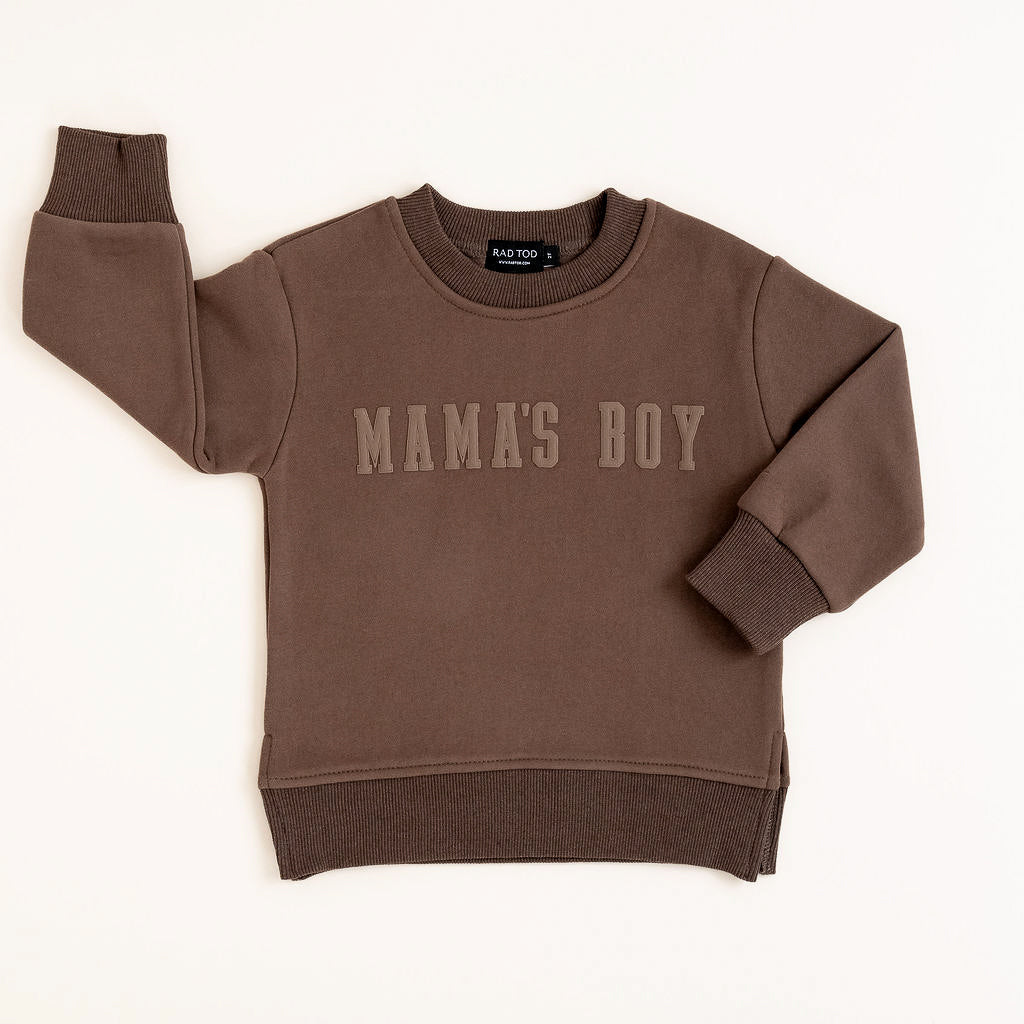 Brown “Mama’s Boy” crewneck with slightly lighter brown lettering, laid flat on a neutral background.