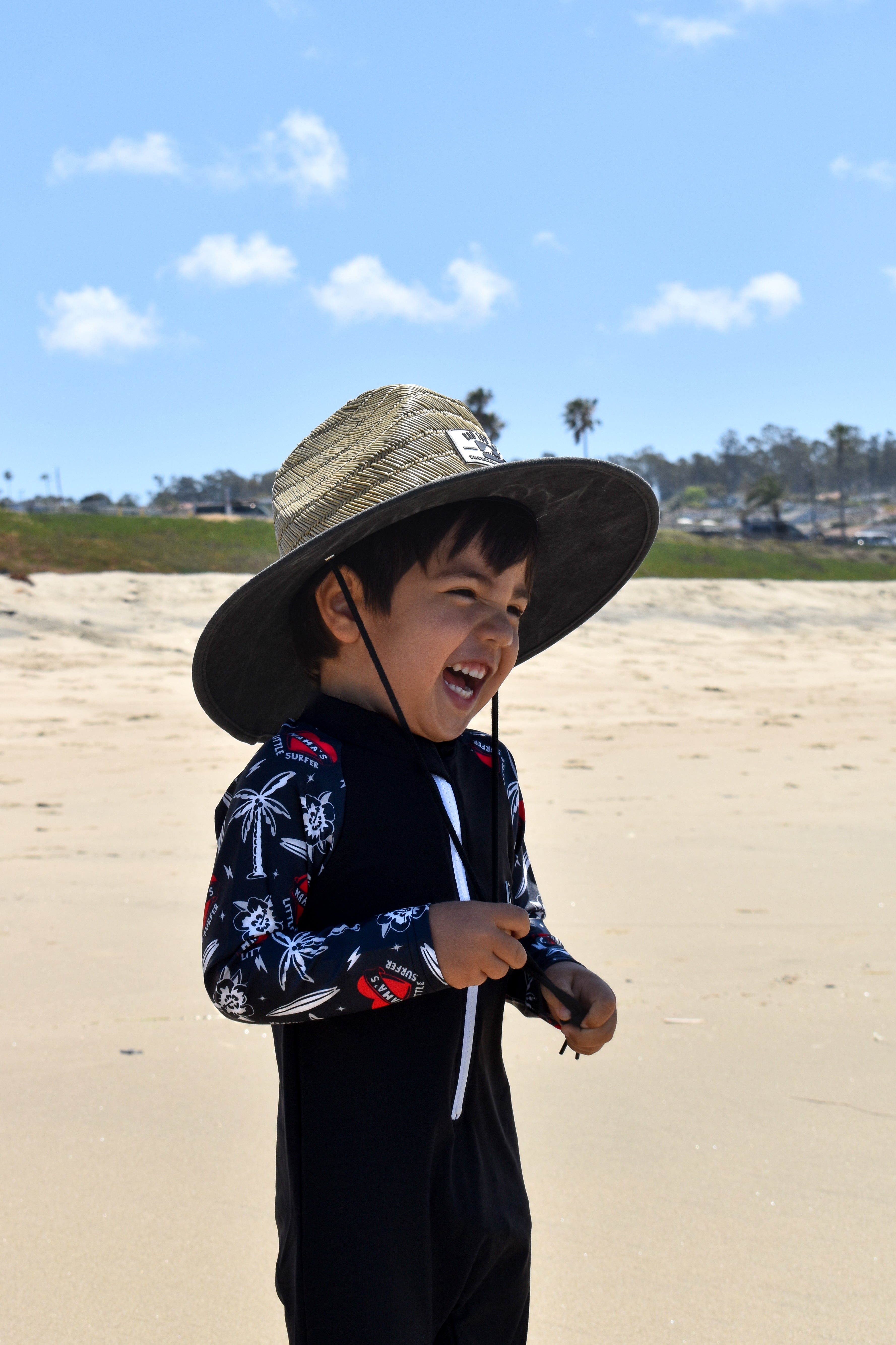 Rashguard onesie paired with staw hat for sun protection