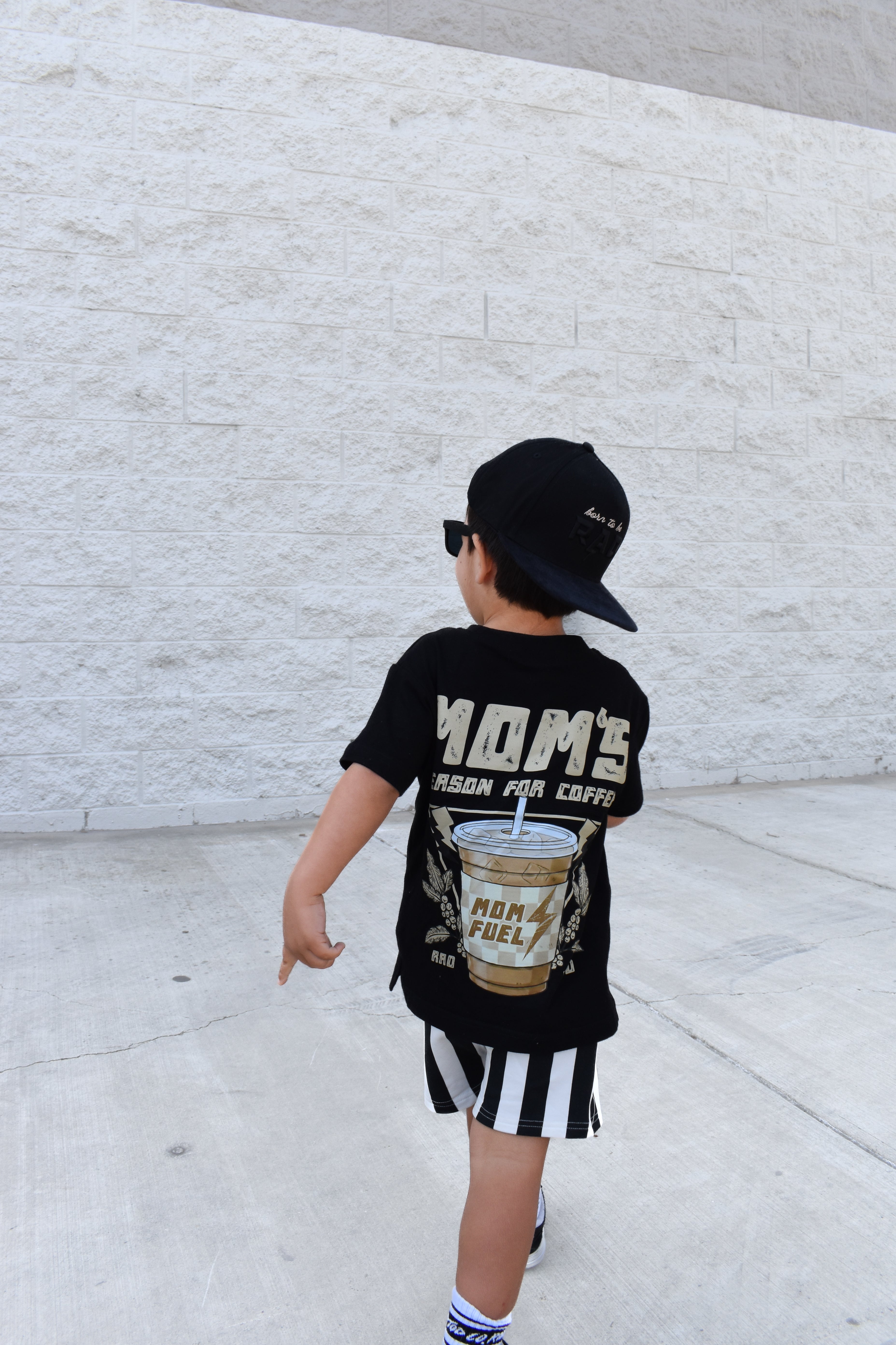 boy walking wearing Kids Riviera Stripe Shorts in black with stripe detail made from soft bamboo cotton blend, breathable and comfortable for all-day wear by Rad Toddler