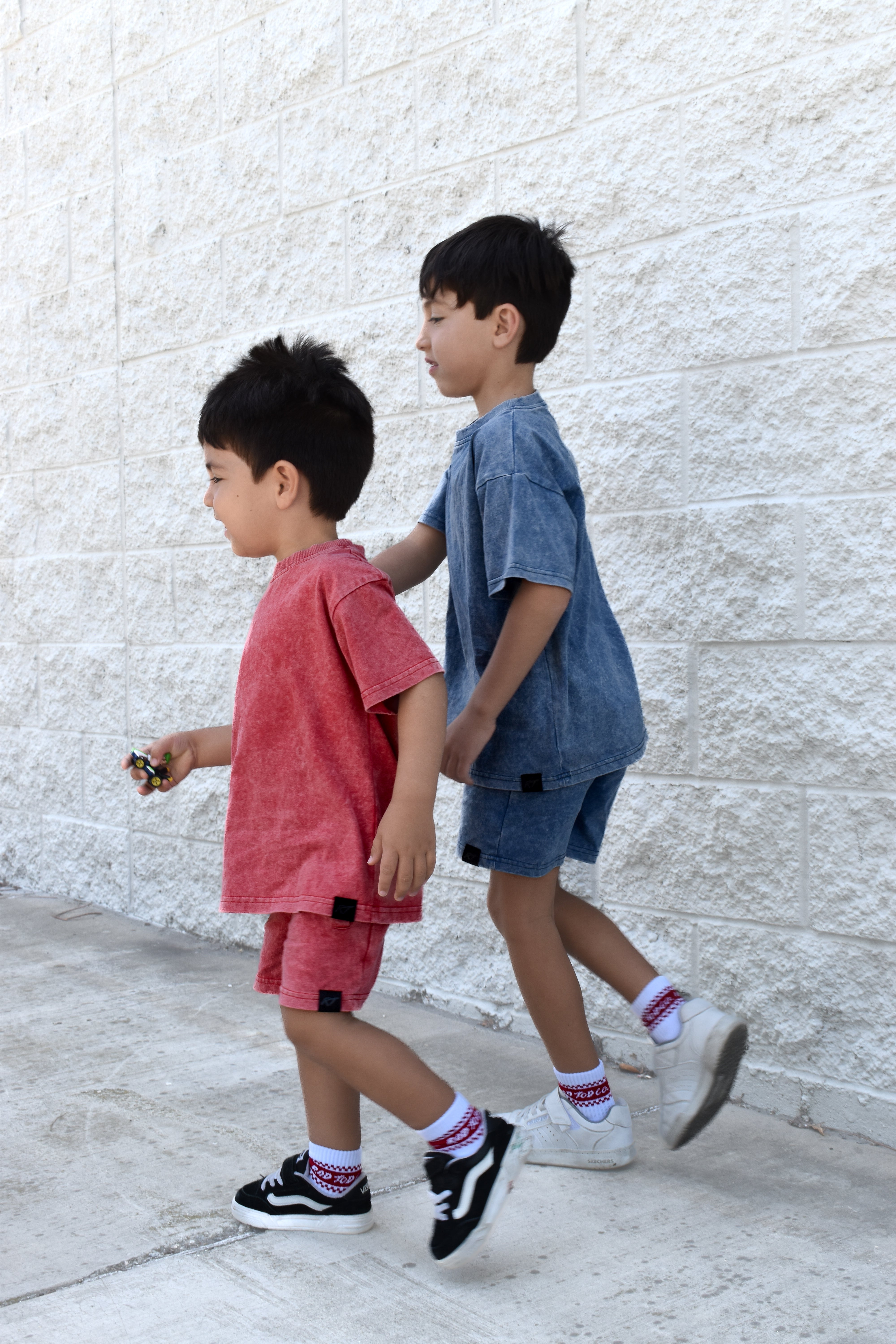 two boys wearing muted red and vintage blue sets by rad toddler