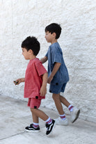 two boys wearing muted red and vintage blue sets by rad toddler