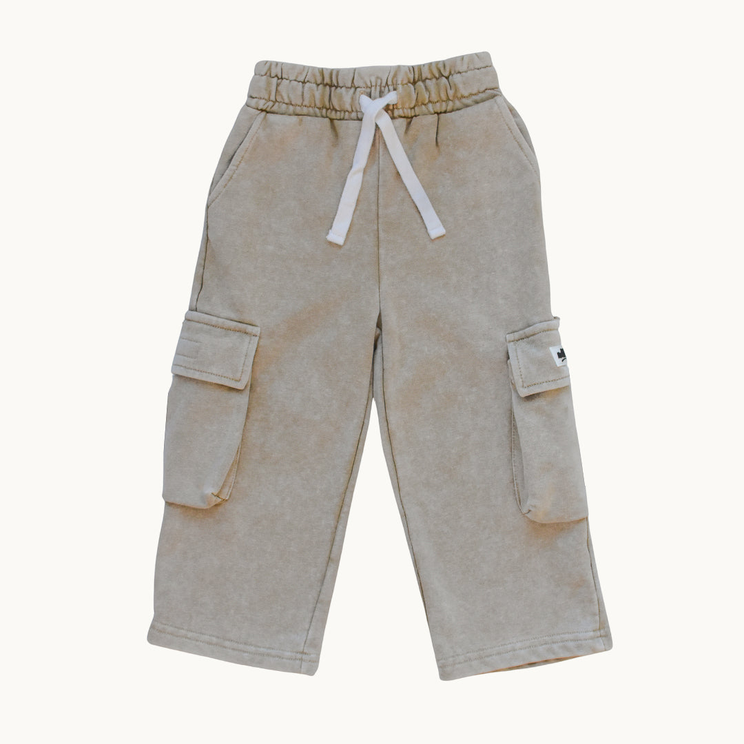A pair of light beige cargo pants with a white drawstring, displayed flat against a solid off-white background.