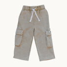 A pair of light beige cargo pants with a white drawstring, displayed flat against a solid off-white background.