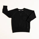 Flat lay of onyx toddler crewneck from the Core Collection with oversized, boxy fit and RT embroidered logo.
