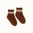 A pair of brown crew socks with a cream and brown patterned cuff featuring the text 'ROD TOD CO.' and small grip dots on the sole, shown on a plain off-white background.