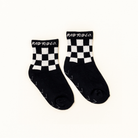 A pair of black crew socks with a white checkerboard pattern around the cuffs and the brand name 'ROD TOD CO.' printed in white on the top of each cuff, displayed on a clean off-white background.