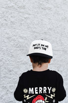 hild wearing Put It On My Dad’s Tab snapback outdoors while playing