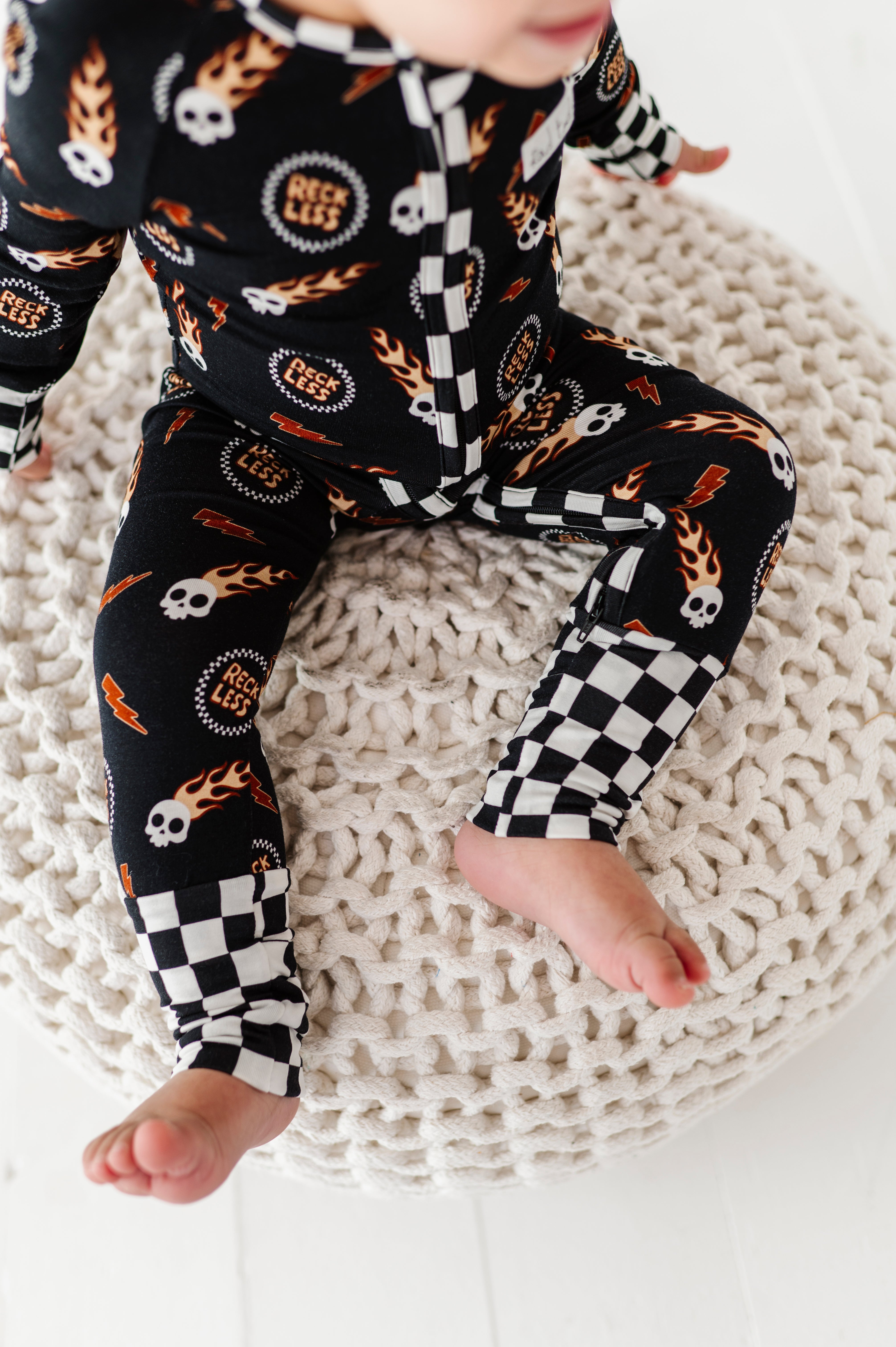 details on Reckless-themed bamboo baby outfit with zipper and fold-over footies