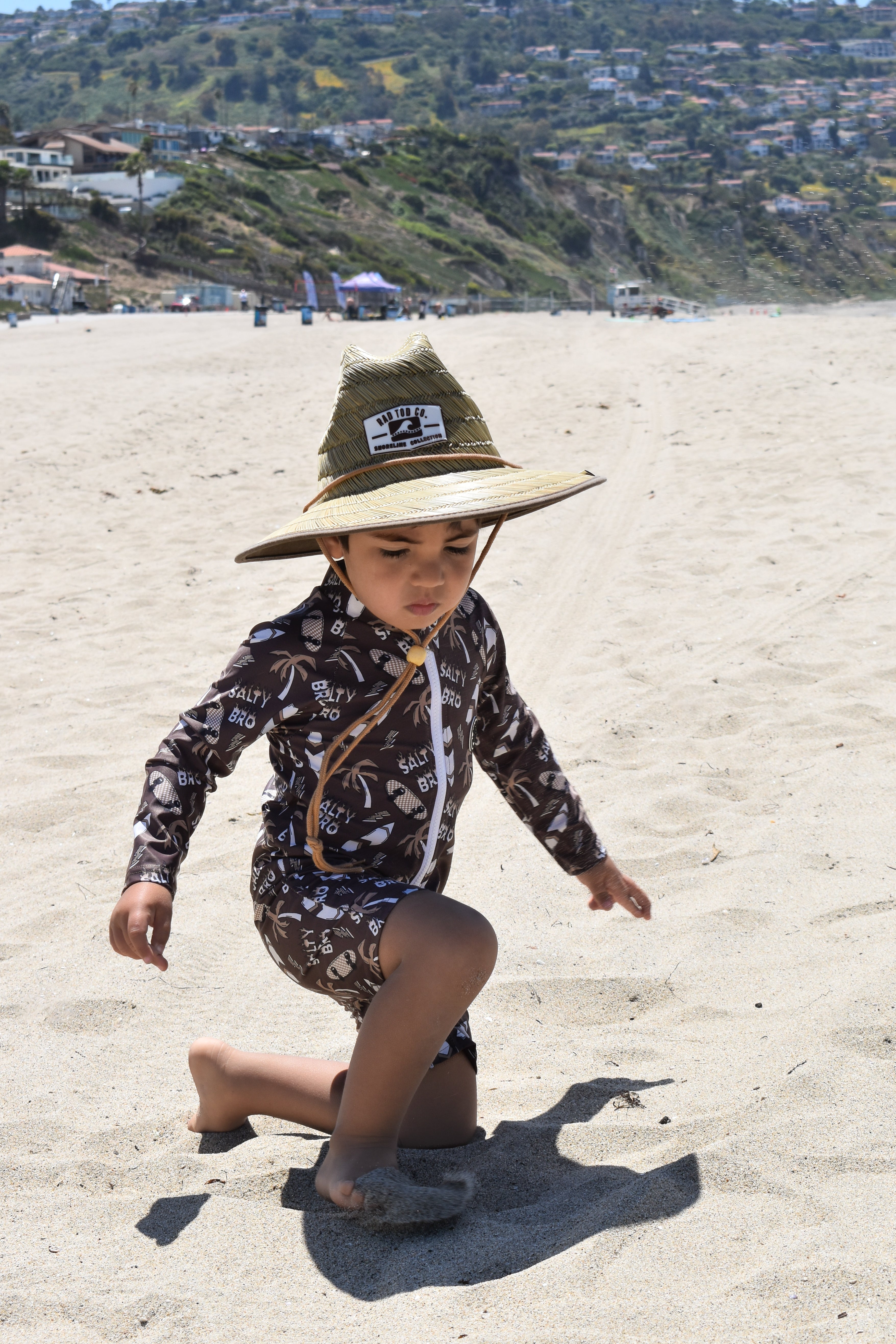 Child wearing rashguard onesie at the beach