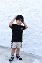 boy wearing black shirt and Sand check shorts with relaxed fit, lightweight polyester fabric, and everyday streetwear style