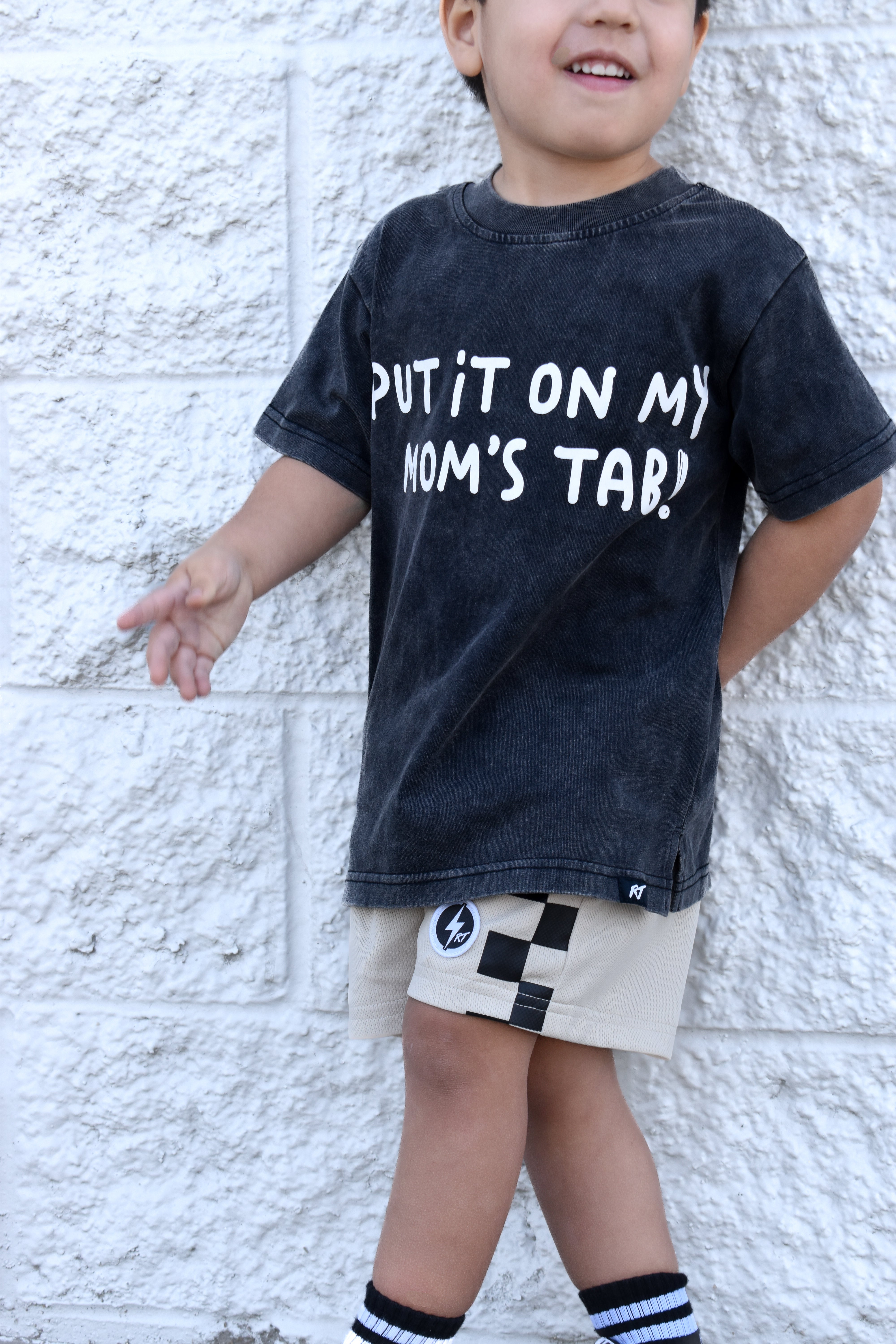 boy wearing black shirt and Sand check shorts with relaxed fit, lightweight polyester fabric, and everyday streetwear style