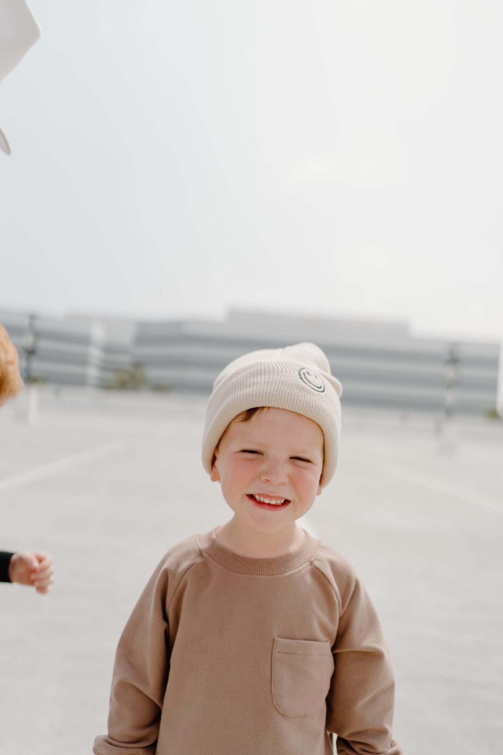 child wearing the bee happy sandstone beanie by rad toddler