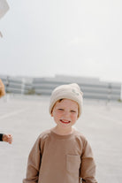 child wearing the bee happy sandstone beanie by rad toddler