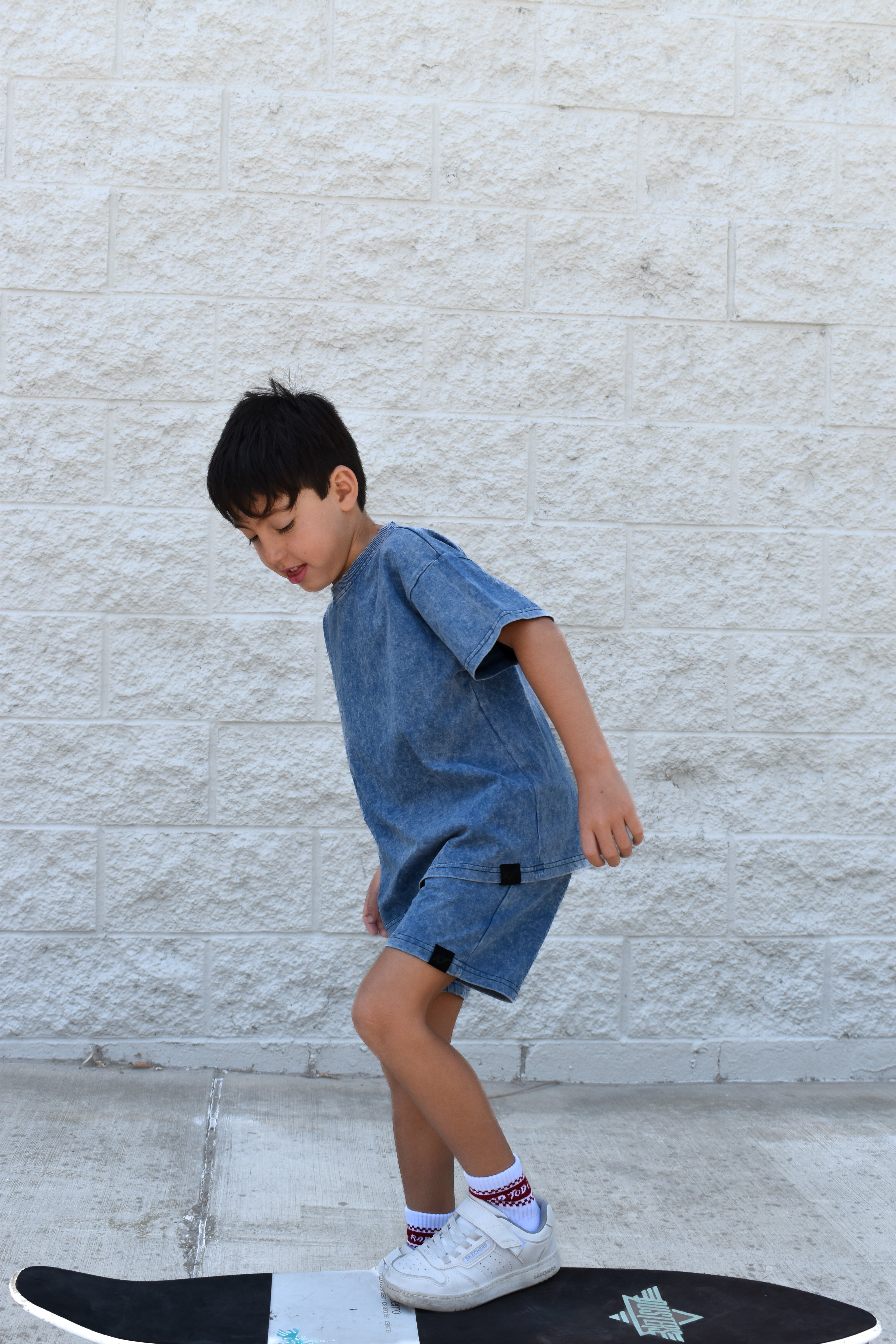 Kids vintage blue stone wash shorts with soft faded fabric, elastic waistband, and relaxed everyday fit paired with matching stone wash tee.