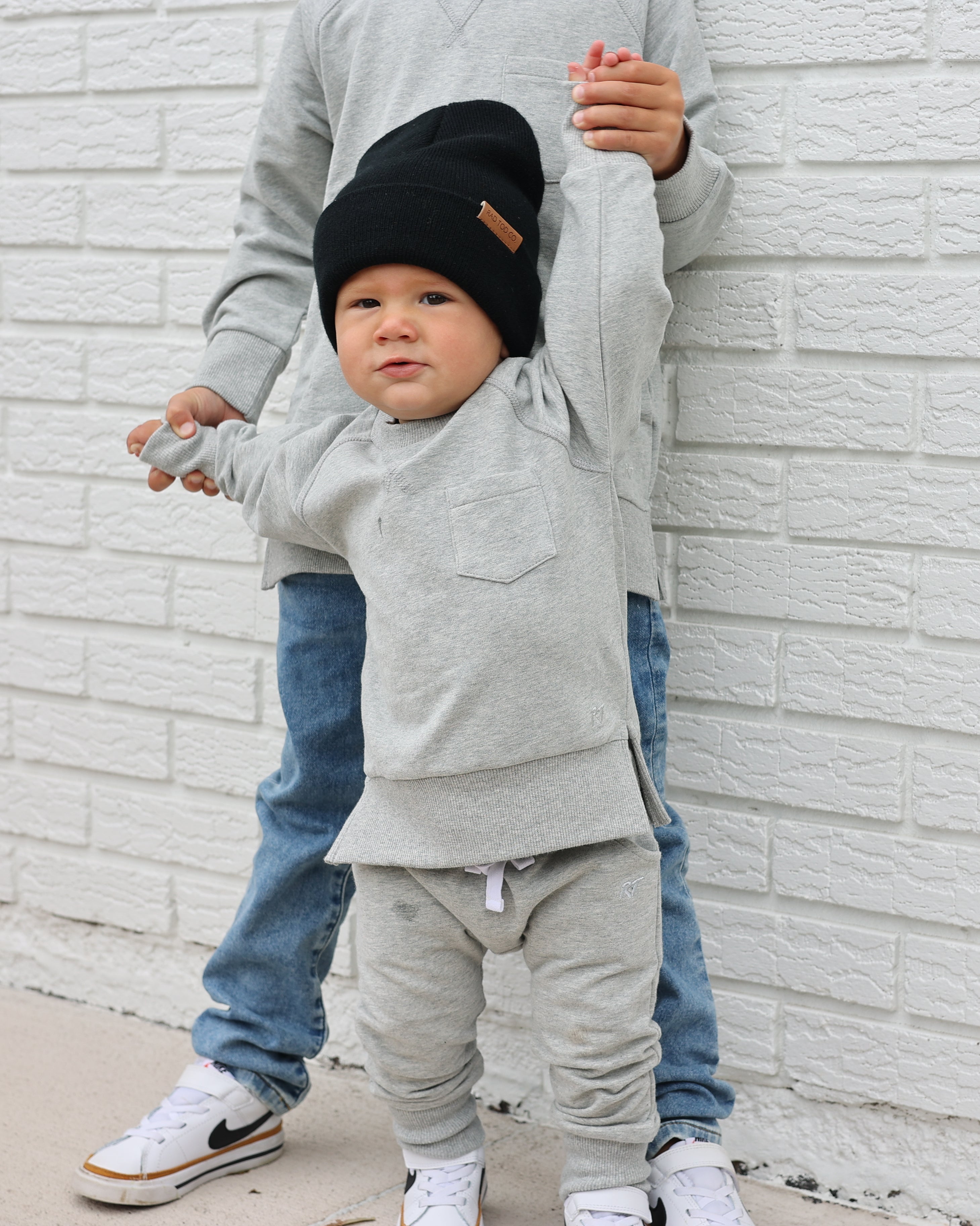 Young boy wearing gray Core Collection toddler crewneck with oversized fit, standing outdoors.
