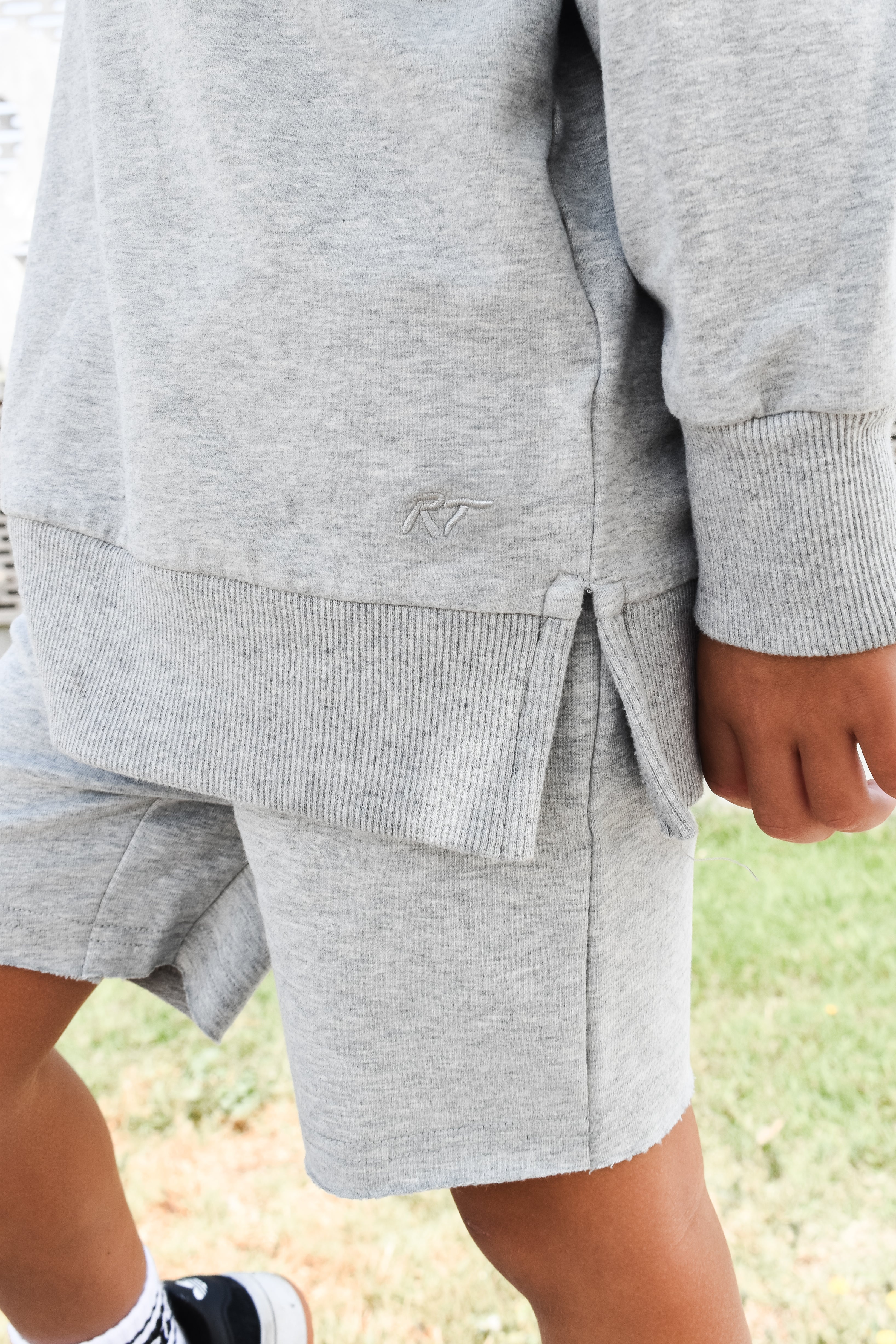 Young boy wearing gray Core Collection toddler crewneck with oversized fit, standing outdoors these are the details