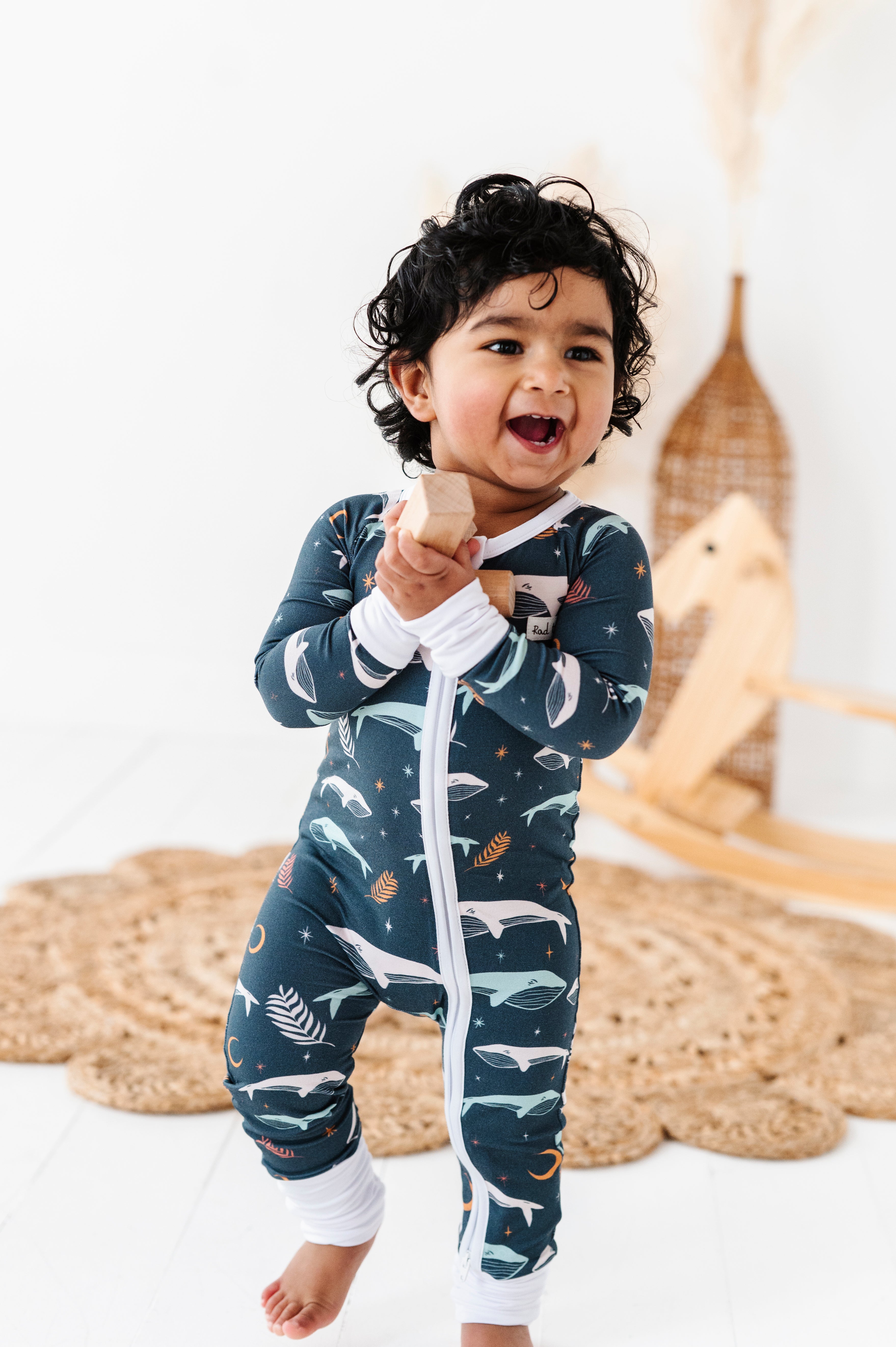 Boy wearing Luna Whale Bamboo Onesie featuring soft, breathable fabric, hypoallergenic properties, and a cute whale design for ultimate comfort and style.