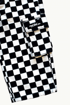Close-up of a black and white checkered cargo pocket with a flap and a visible 'Rad Tod CO.' label, on a light off-white background.