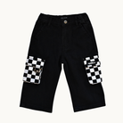 Black cargo shorts with large flap pockets featuring a black and white checkered pattern, shown flat on a light cream background.