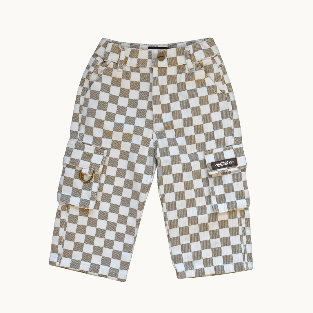 A pair of denim pants featuring a beige and white checkerboard pattern, with side cargo pockets and a small brown brand patch on the right pocket, displayed against a solid off-white background.
