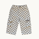 A pair of denim pants featuring a beige and white checkerboard pattern, with side cargo pockets and a small brown brand patch on the right pocket, displayed against a solid off-white background.